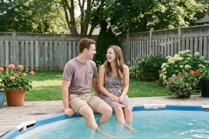Jeune couple souriant près d'une piscine dans le jardin